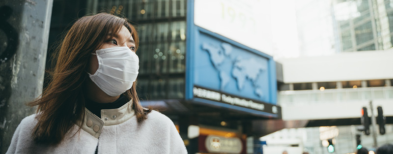 Young Asian woman wearing a protective face mask in the city.