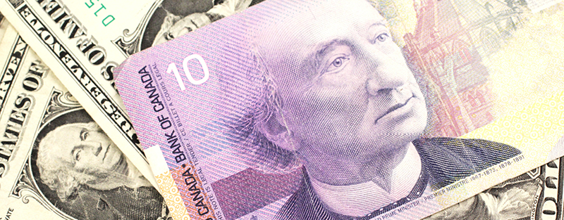 A Canadian ten dollar bill on a background of dollar bills