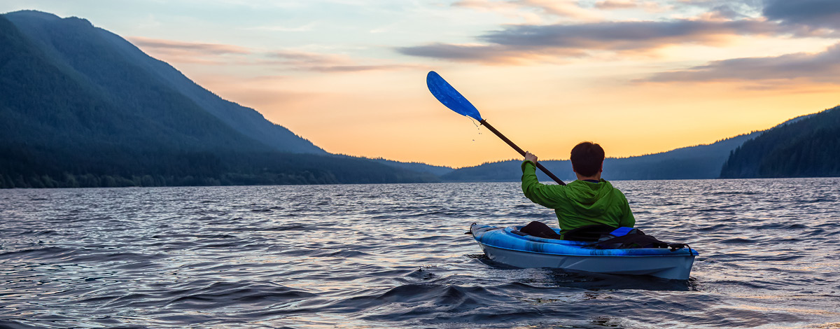 Personne kayak sur un lac pittoresque au coucher du soleil dans le parc provincial Golden Ears, près de Vancouver, Colombie-Britannique, Canada.