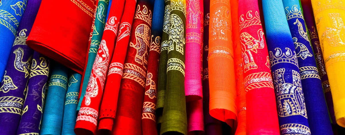 A display of colorful woven fabrics from India.