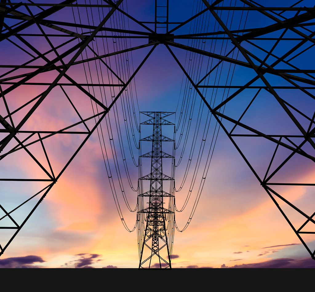 Silhouette of high voltage towers and a colourful sky.