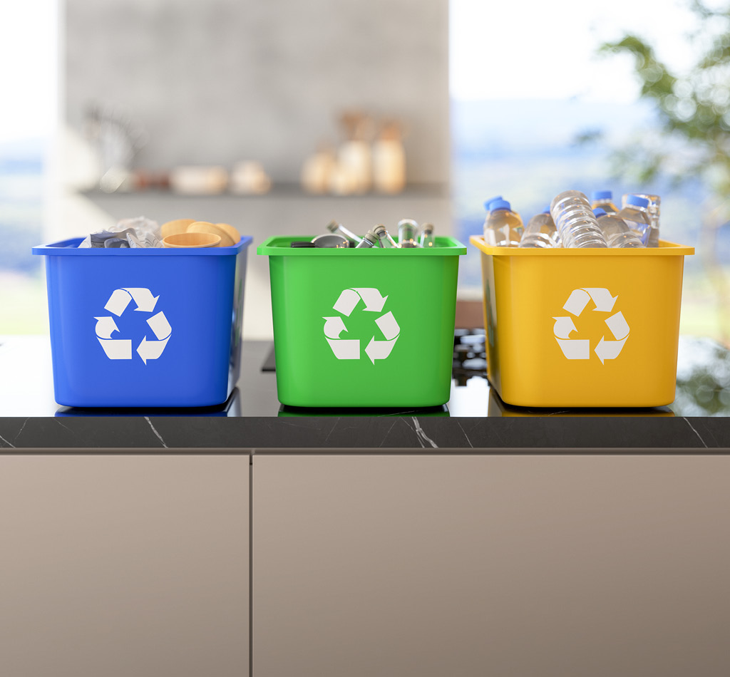 Three recycling bins on a kitchen island.