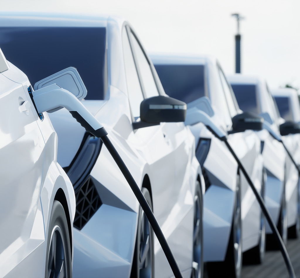 White electric cars charging on a city street.