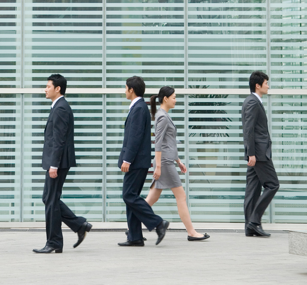 Business people walking in front of a building in Beijing, China.