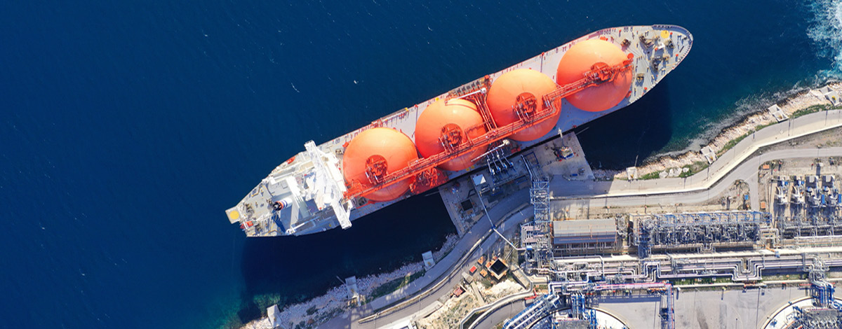 Top down view of LNG (Liquified Natural Gas) tanker anchored in small gas terminal island.