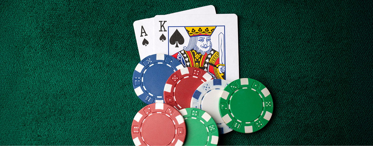 Ace of spades, king of spades, and a stack of poker chips on the table.