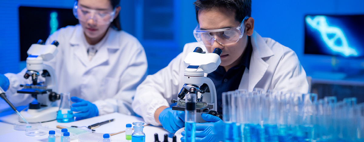 Two scientists looking through microscopes.