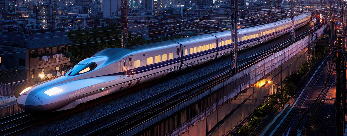 A Japanese "Shinkansen" (or bullet train), traveling through the Tokyo cityscape at dusk.