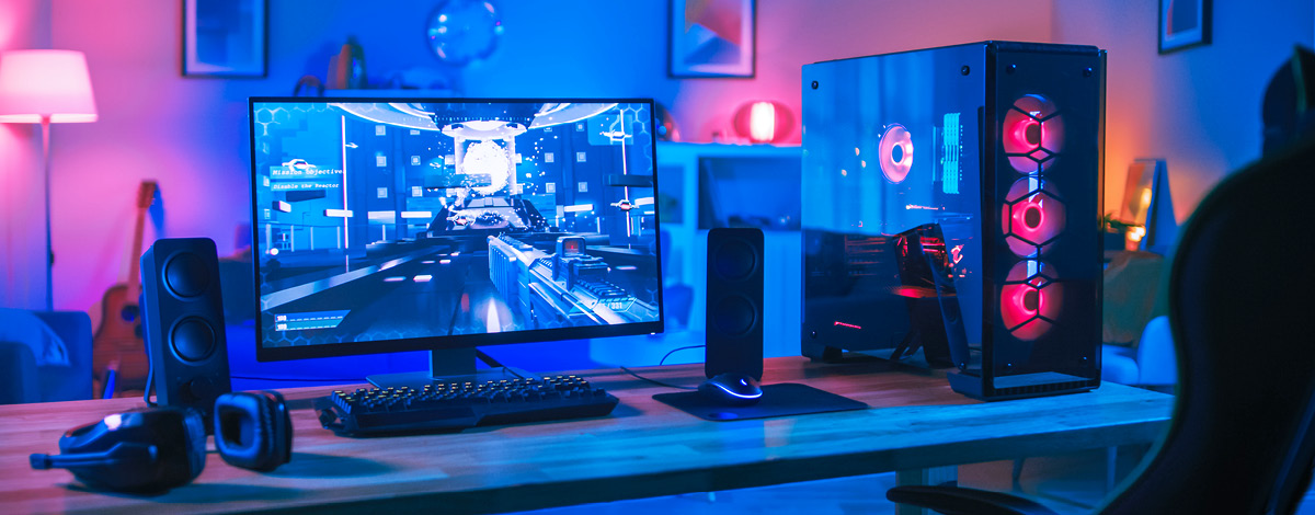 A high-performance personal computer displaying a modern video game in a room illuminated by futuristic neon lighting.