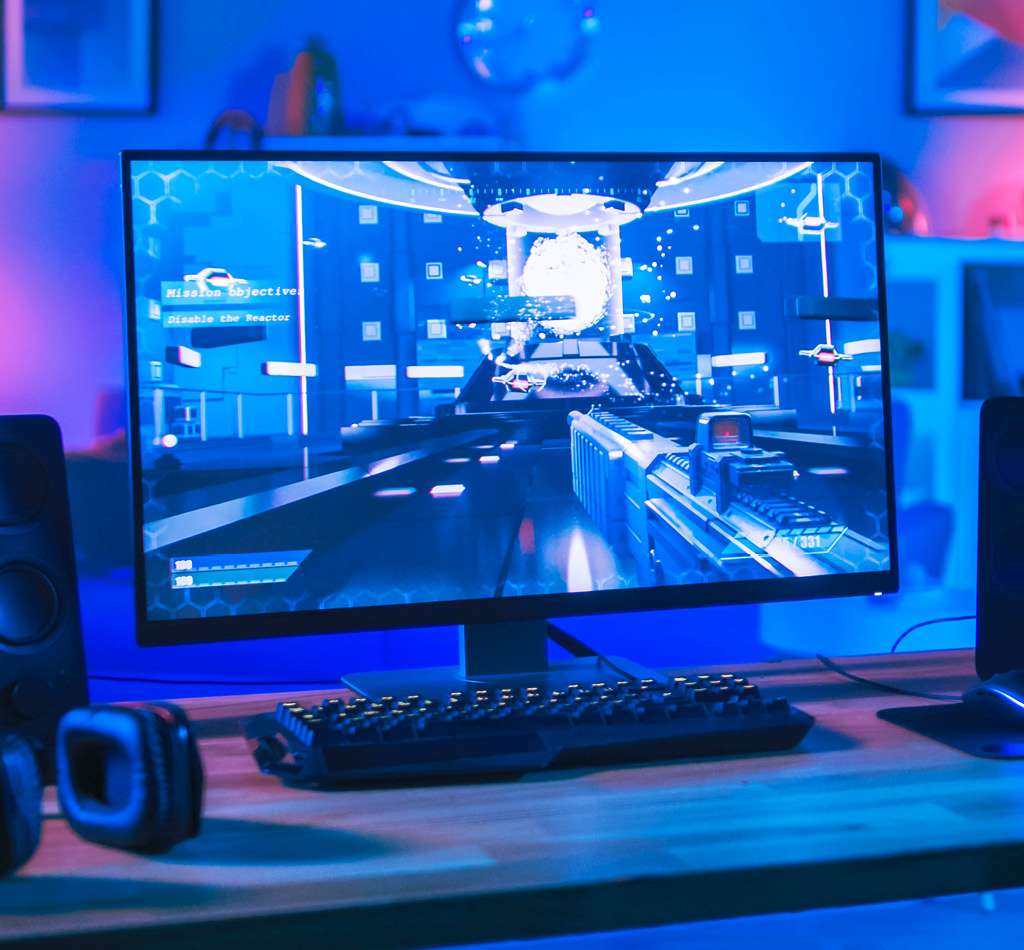 A high-performance personal computer displaying a modern video game in a room illuminated by futuristic neon lighting.