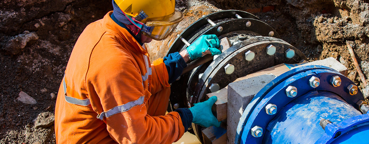 Old water pipes joined with new blue valves and new blue joint members.