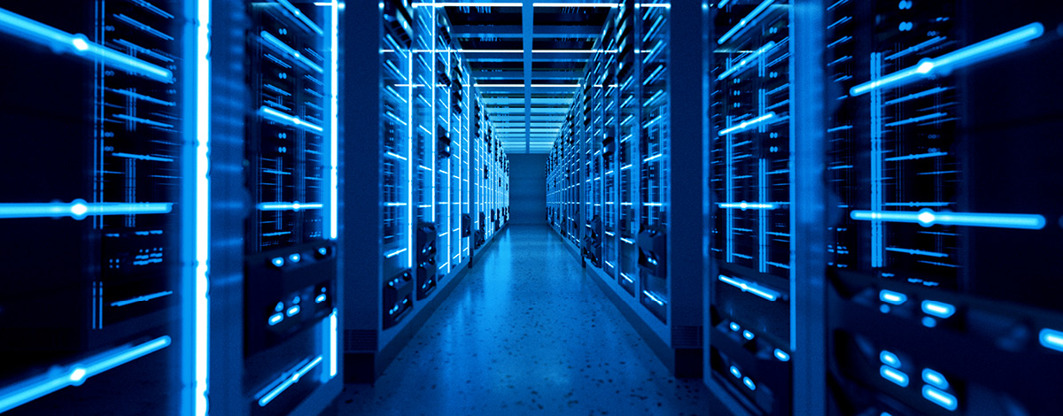 Corridor of server racks in a data center, illuminated with blue LED lights.
