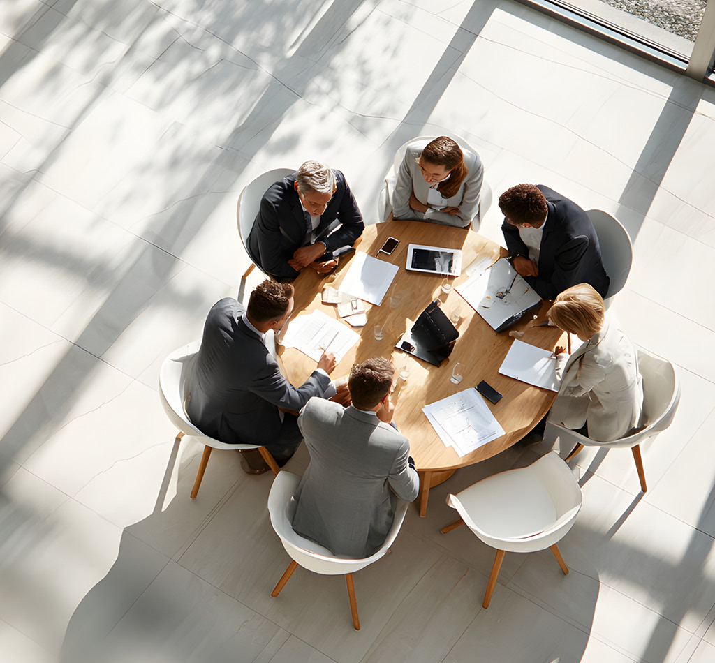 Top-down view of a meeting with 6 people sitting at a table.