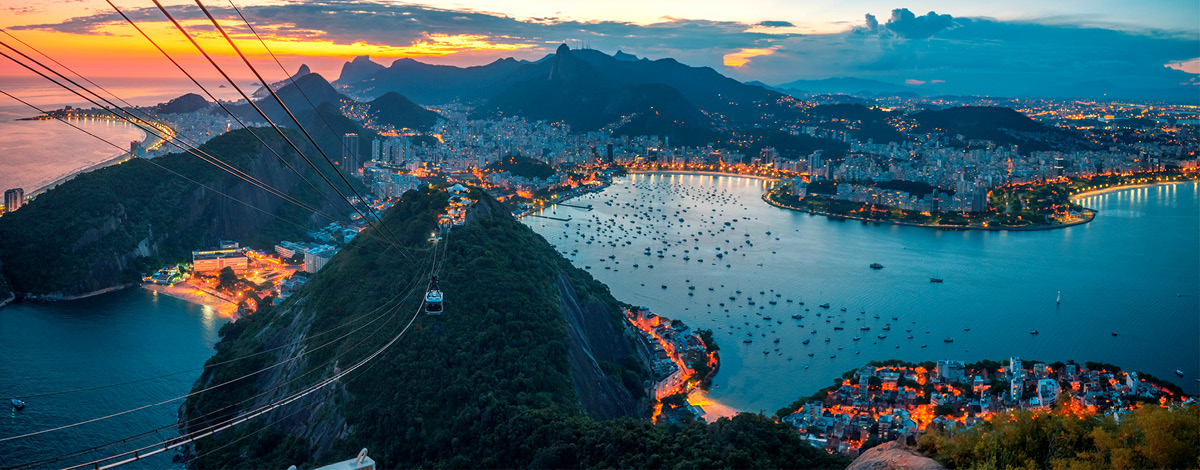 Panoramic view of the illuminated coastline of Guanabara Bay, Rio de Janeiro at dusk.