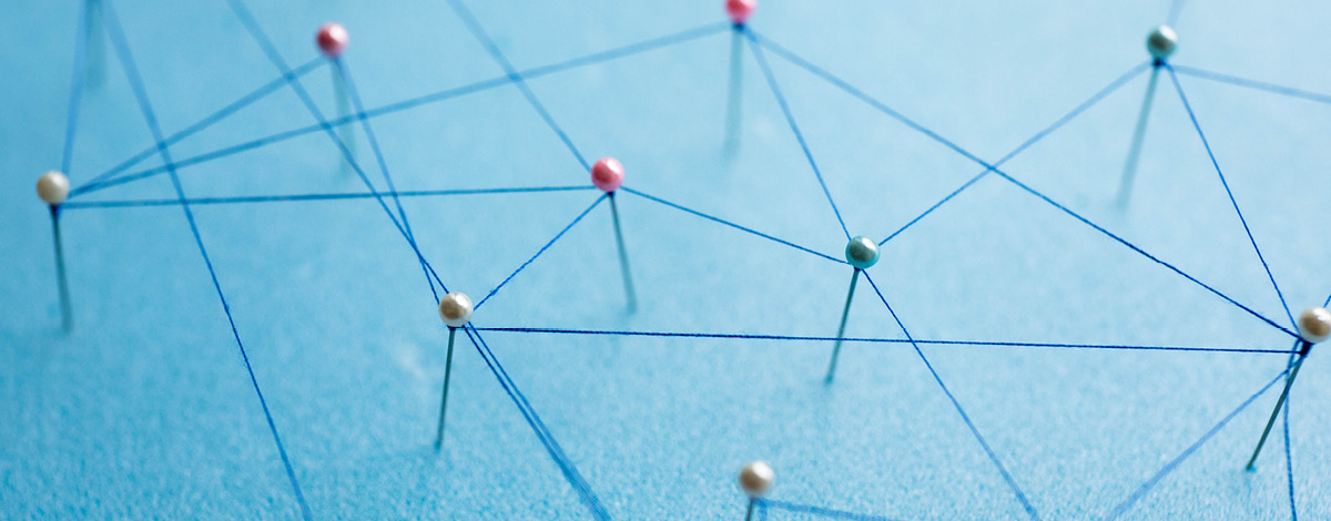 Various pins connected by a blue string, representing a digital network and information sharing.